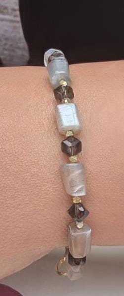 The bracelet, made of horizontal Moon Stone beads contrasted with faceted Smoky Topaz beads, and interspersed with bicone gold spacers.