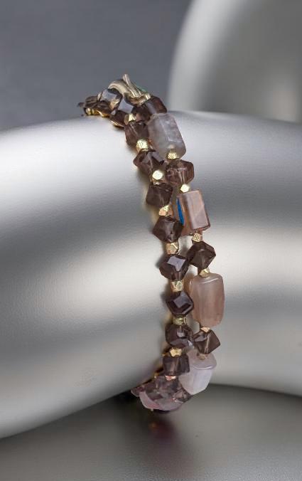The bracelet, made of horizontal Moon Stone beads contrasted with faceted Smoky Topaz beads, and interspersed with bicone gold spacers.