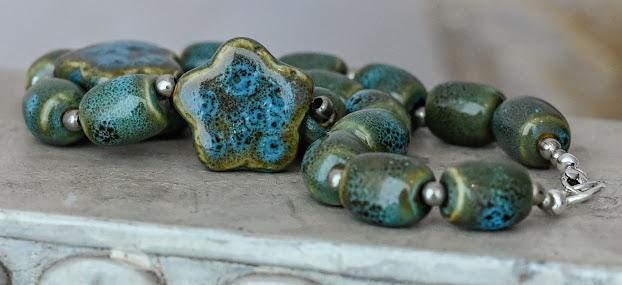 Artisan Ceramic Chunky Necklace. With shades of blue and tan, oval-shaped beads interspersed with star-shaped focals. Glossy with texture.