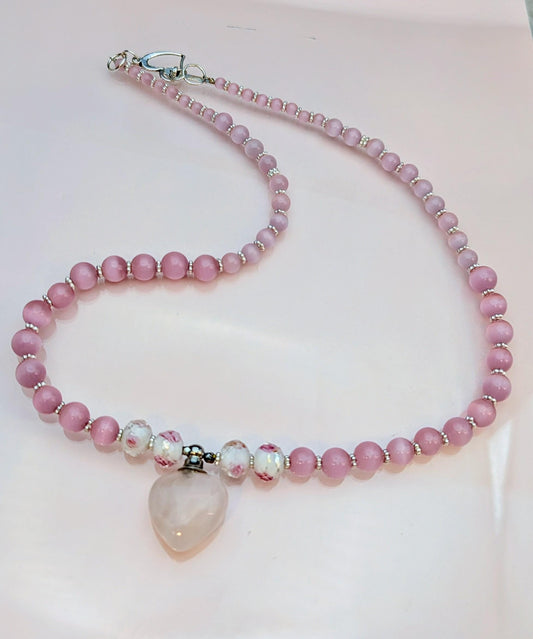 Rose Quarts perfume bottle pendant on a pink Cats Eye Beaded necklace.  Off-set with 2 white beads with rose design to enhance the pendant.