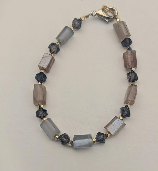 The bracelet, made of horizontal Moon Stone beads contrasted with faceted Smoky Topaz beads, and interspersed with bicone gold spacers.