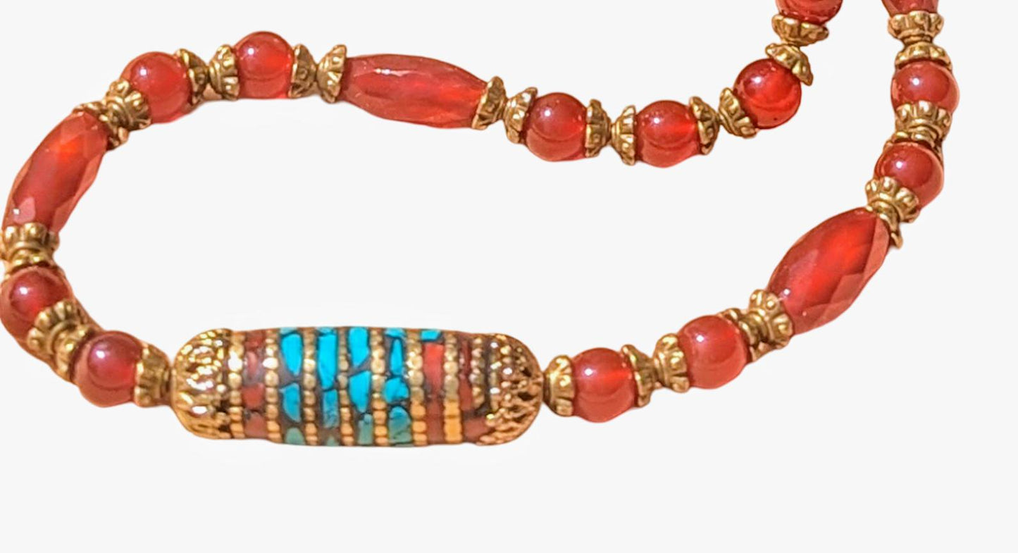 Carnelian necklace with Tibetan focal bead that is trimmed in turquoise.
