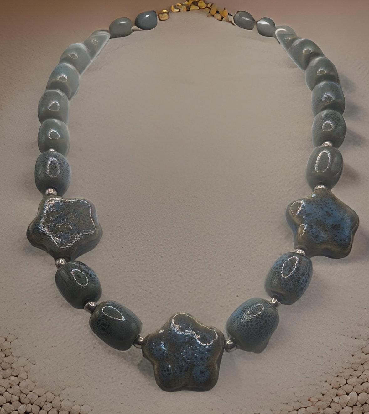 Artisan Ceramic Chunky Necklace. With shades of blue and tan, oval-shaped beads interspersed with star-shaped focals.  Glossy with texture.